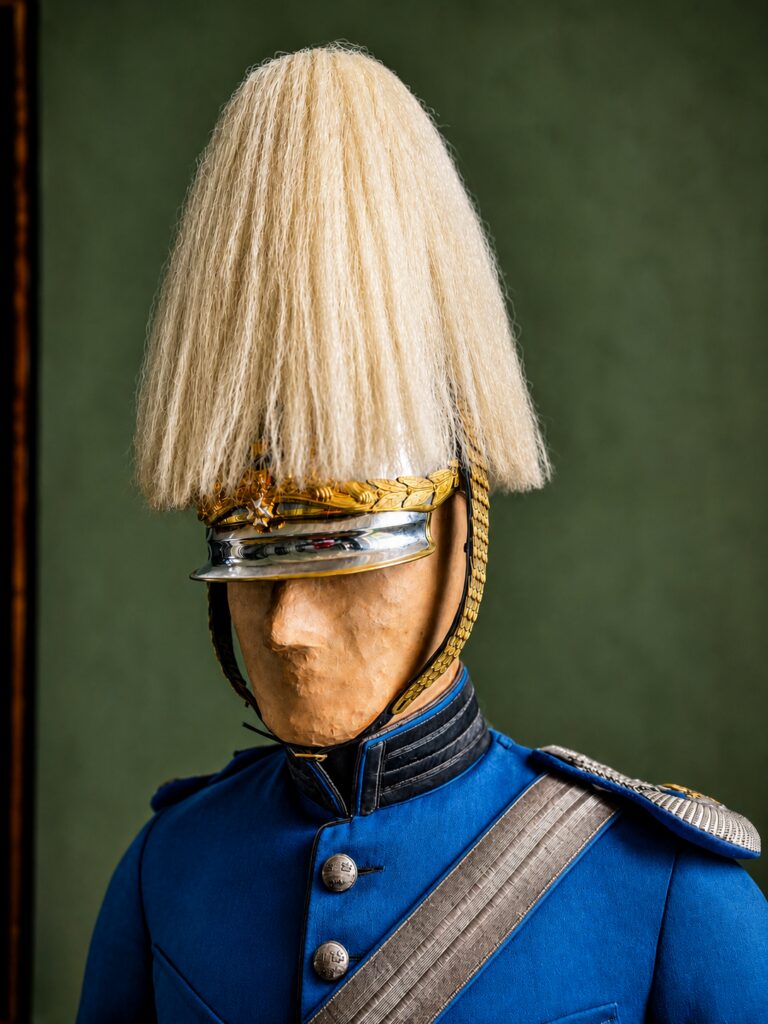 Kavallerist i blå uniform och hjälm med vit plym